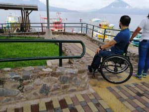 Imagen de una persona sentada en silla de ruedas viento hacia el lago Atitilán